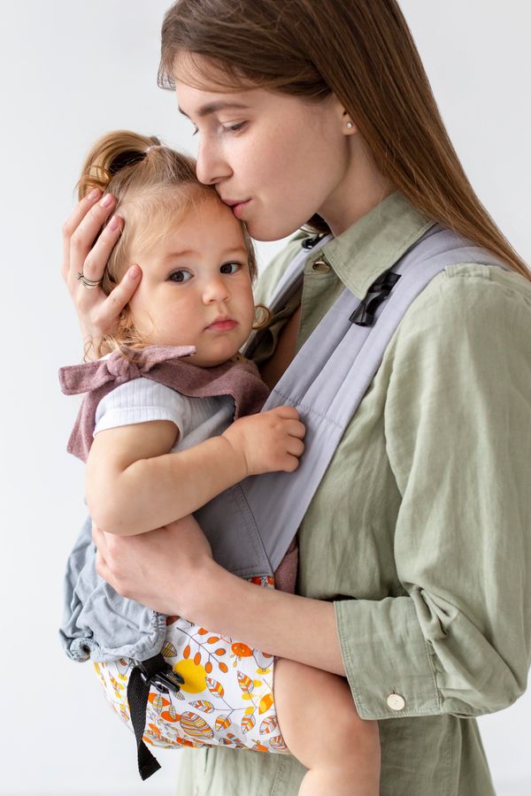 A young woman kissing her daughter on the head | Source: Freepik