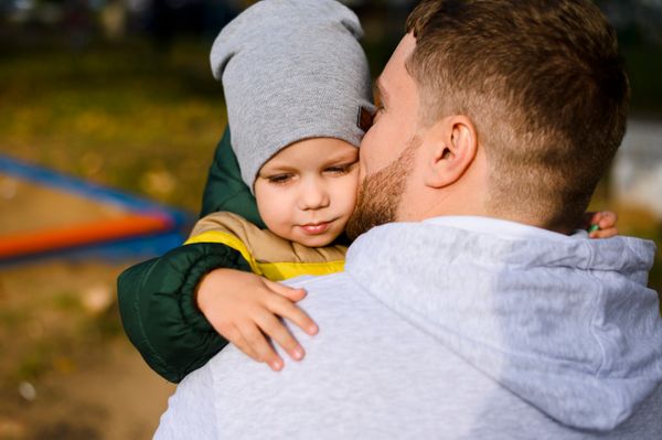 A young man holding a young child | Source: Freepik