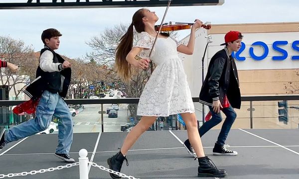 Young Girl Joins The Dancers While Playing Footloose On The Violin