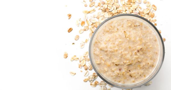 Handmade oatmeal face mask and ingredient on white background, top view.