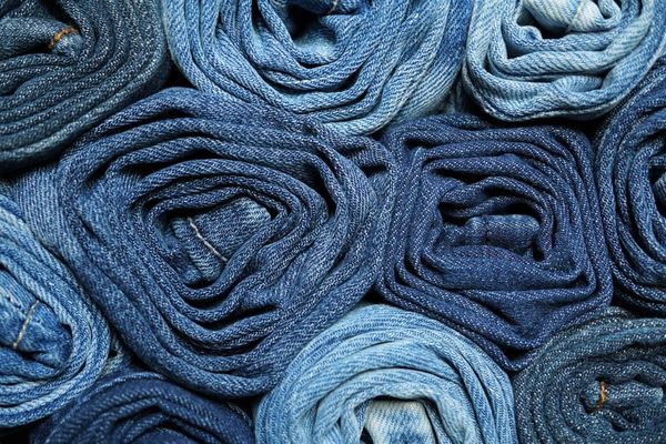 Pairs of rolled jeans stacked together.